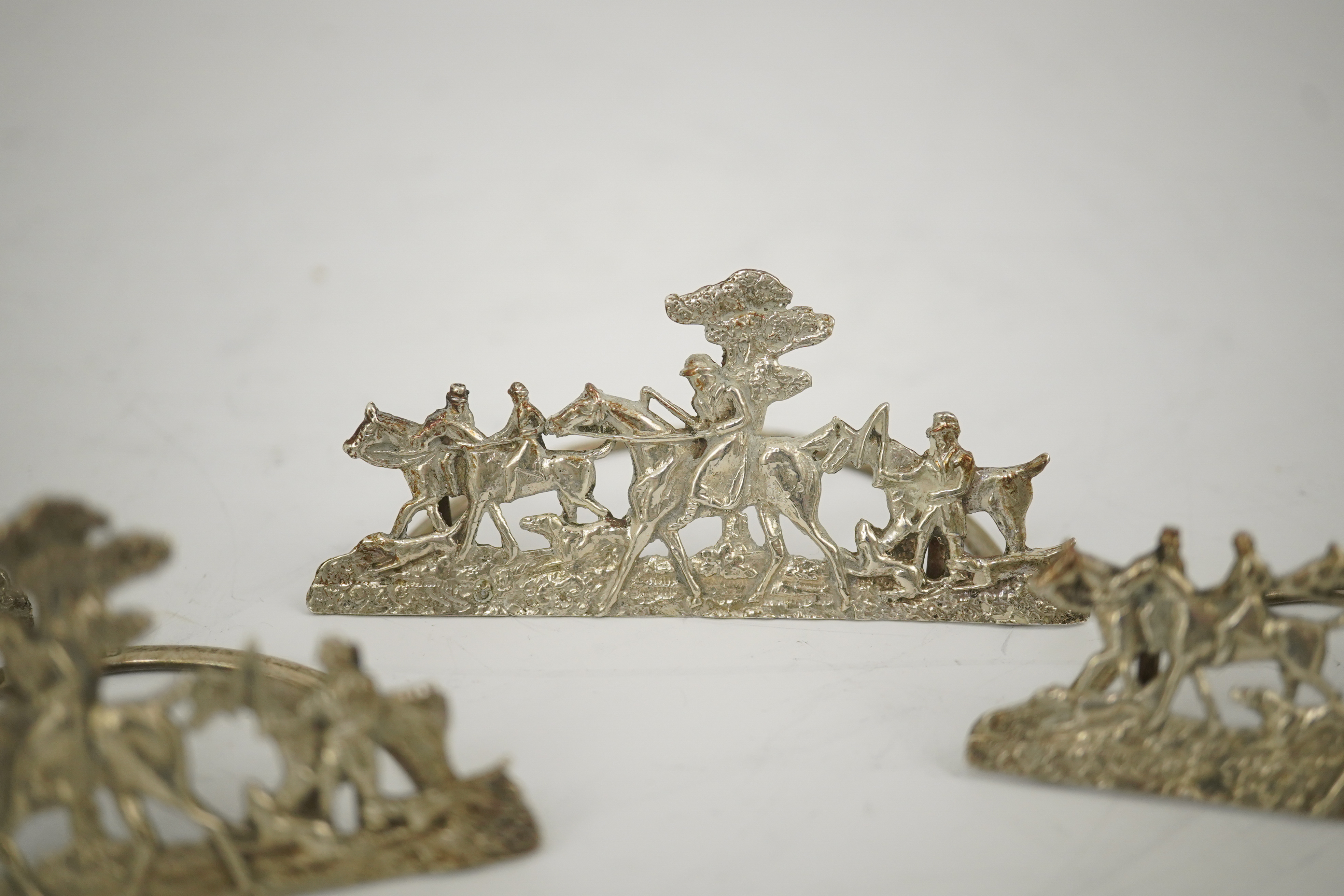 A set of four Edwardian pierced silver 'hunting scene' menu holders, by Stuart Clifford